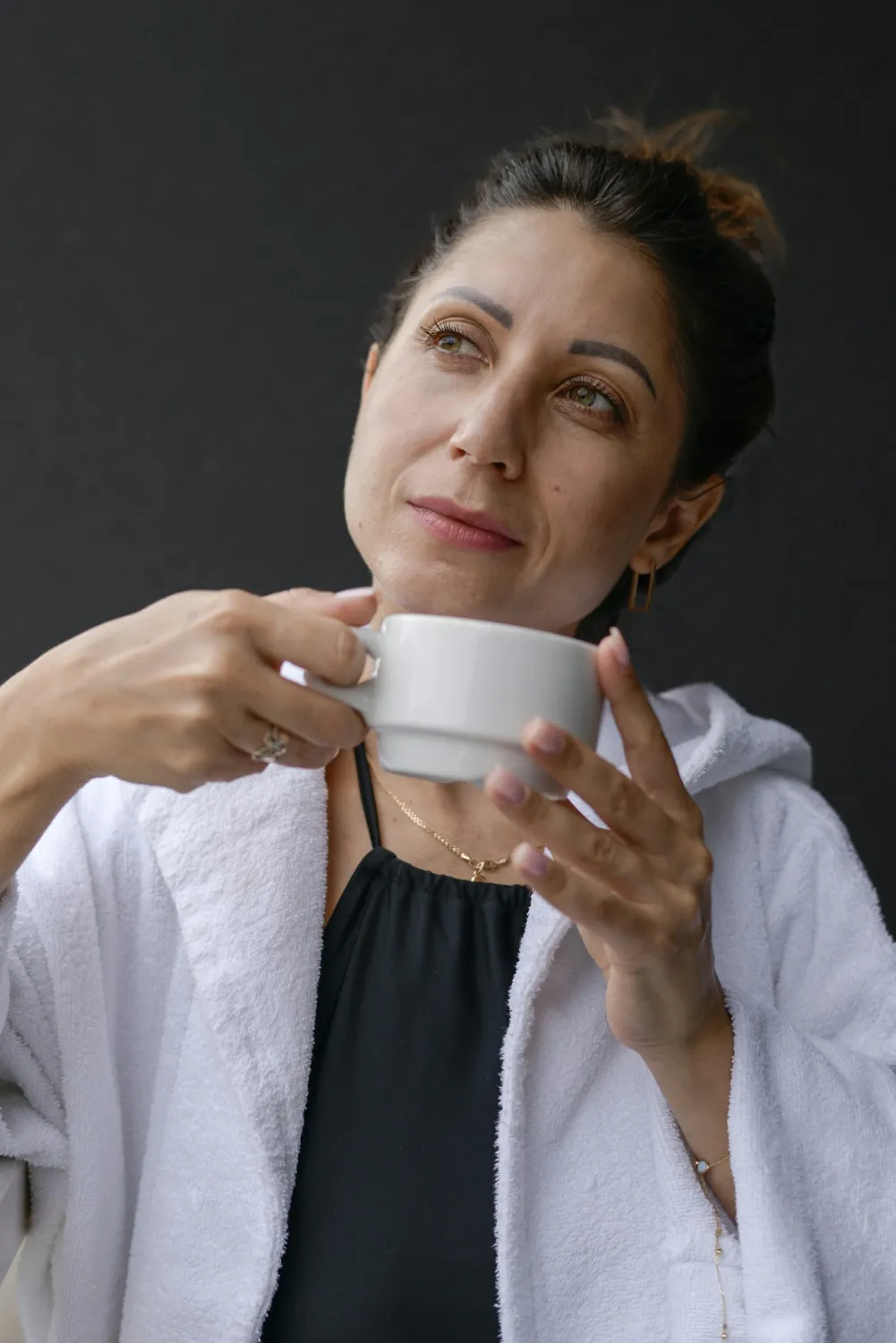 Una donna tiene tra le mani una tazza calda e si prende un momento per sé